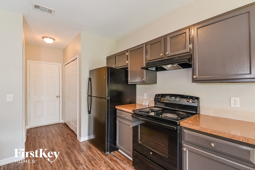 a kitchen with stainless steel appliances and a black refrigerator