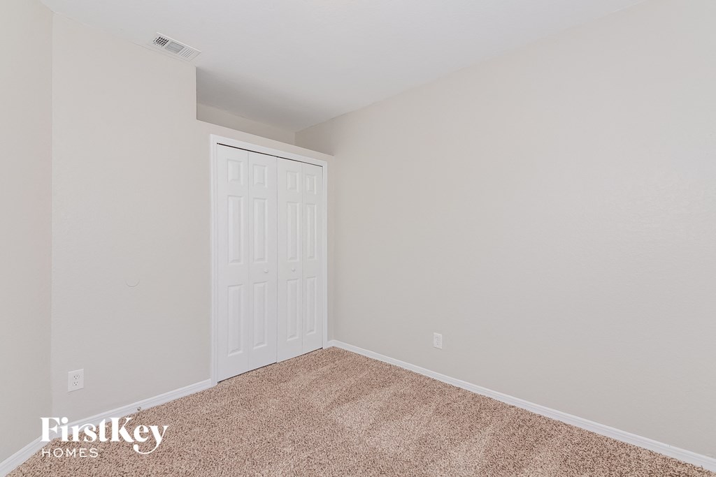 a bedroom with a white door and a carpeted floor