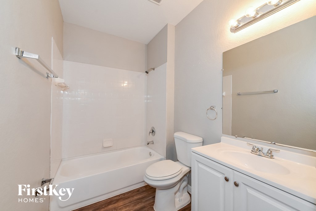 a bathroom with a toilet and a tub and a sink