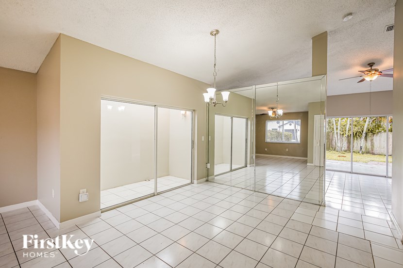 A spacious room with a tiled floor and a ceiling fan.