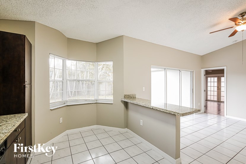 A spacious room with a tiled floor and a ceiling fan.