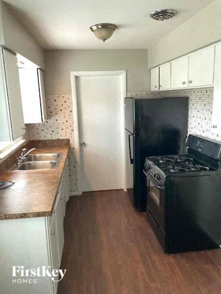 a small kitchen with a stove refrigerator and sink