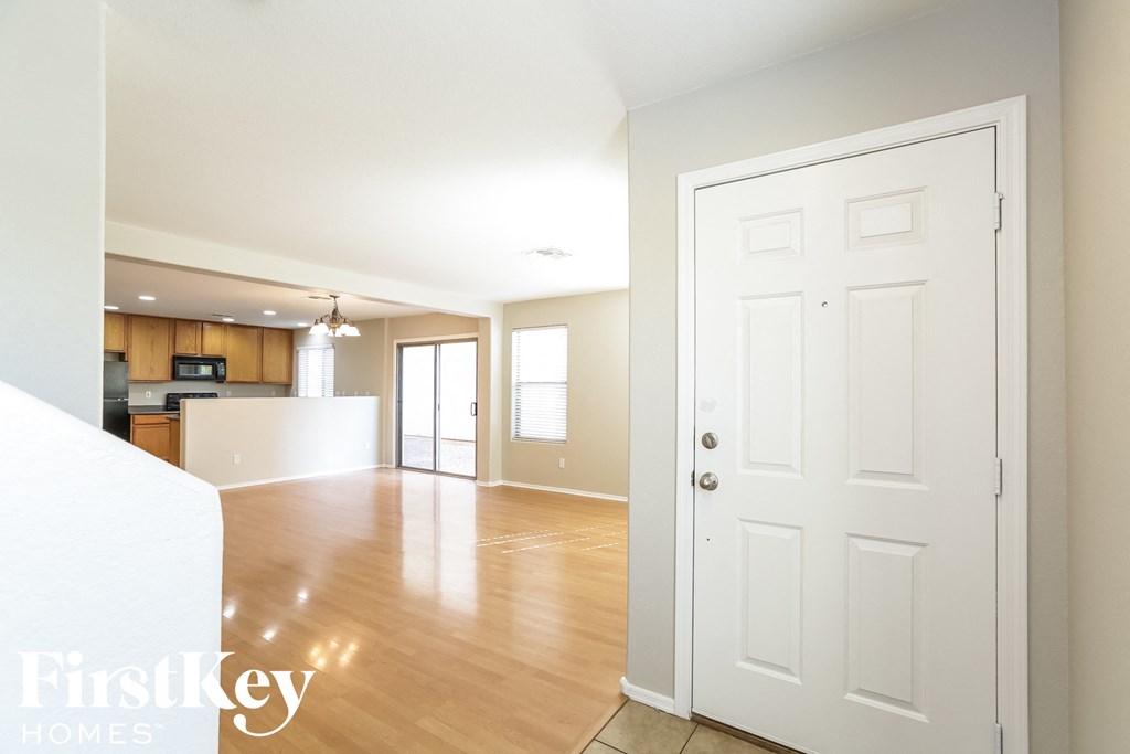 an empty living room and kitchen with a white door