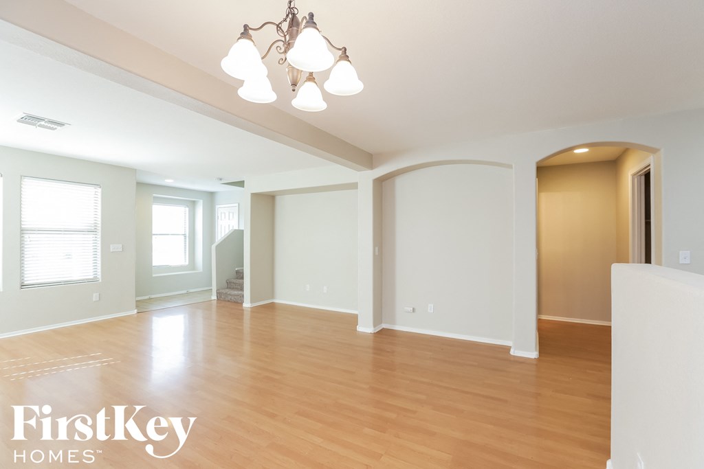 an empty living room with wood flooring and white walls