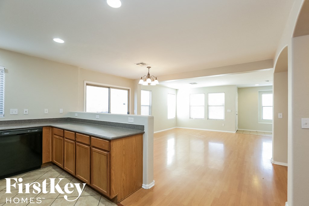 an empty kitchen and living room with wood floors and a counter top