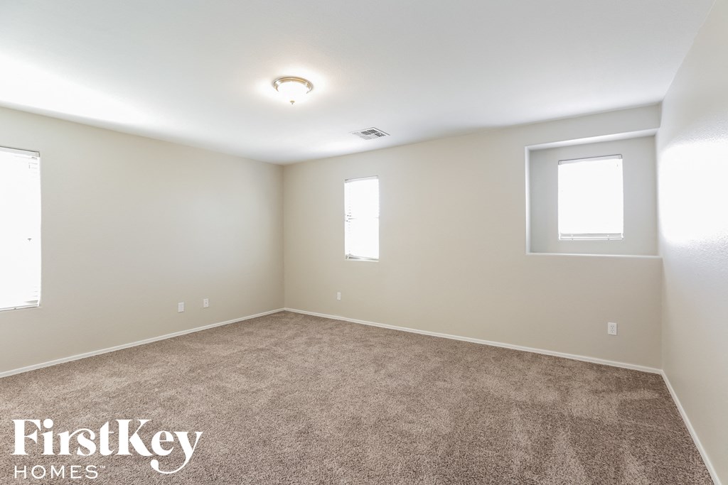 the living room of a new home with carpet and two windows