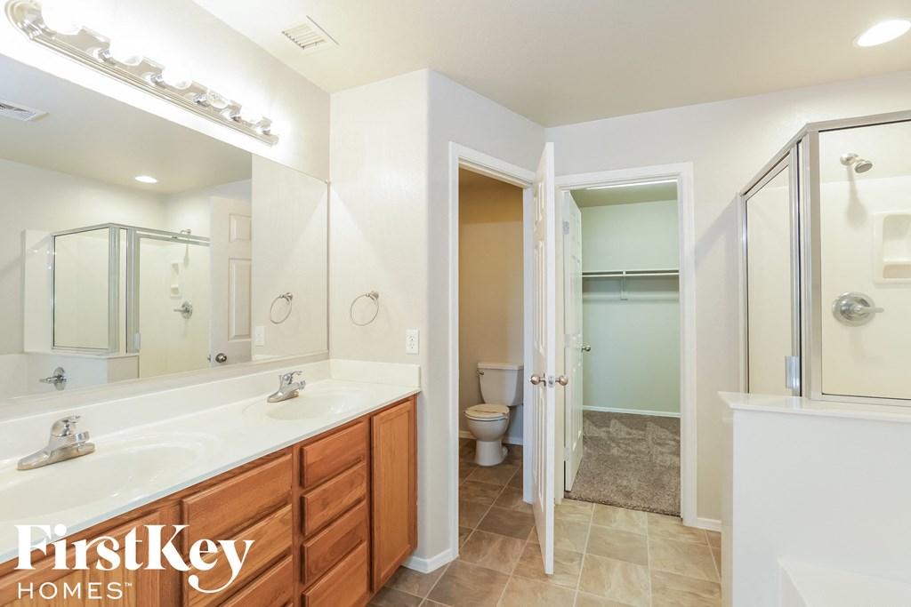 a bathroom with two sinks and a shower and a toilet