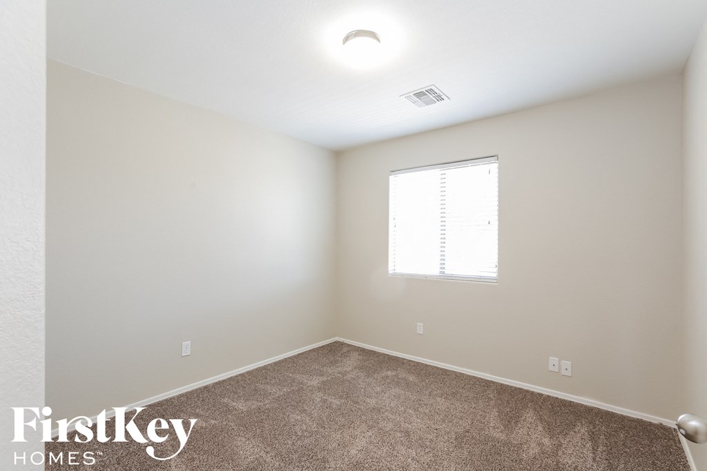 a bedroom with a carpeted floor and a window