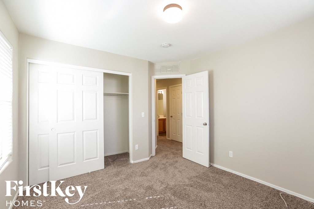 a master bedroom with two closets and a carpeted floor
