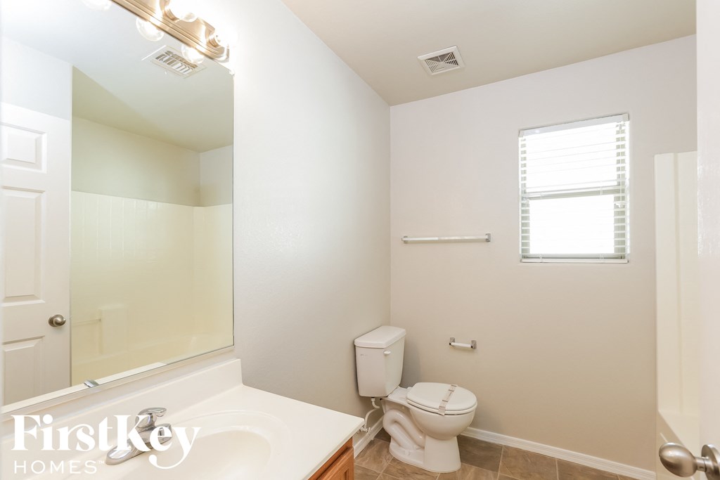 a bathroom with a toilet and a sink and a mirror