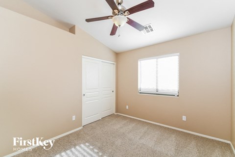 the master bedroom has a ceiling fan and a closet