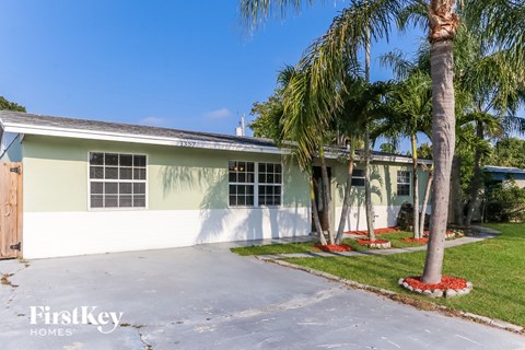 a yellow house with palm trees in front of it