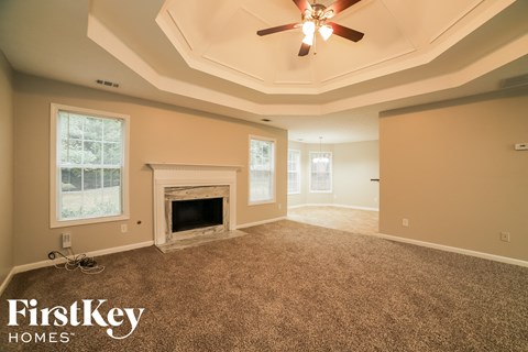 a living room with a fireplace and a ceiling fan
