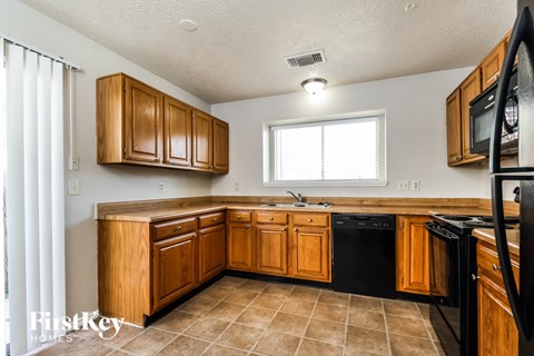 A kitchen with wooden cabinets and black appliances.