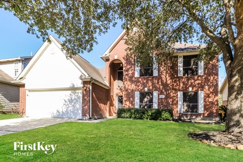 A brick house with a tree in front of it.