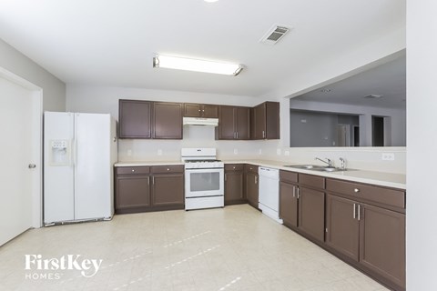 A kitchen with brown cabinets and white appliances.