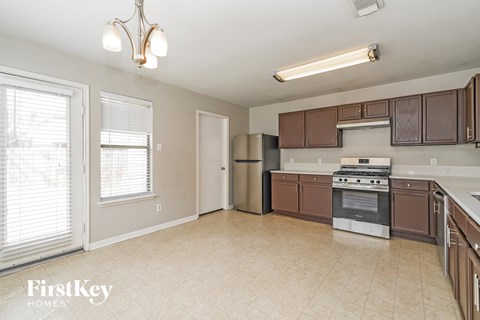 A kitchen with brown cabinets and a stainless steel refrigerator.