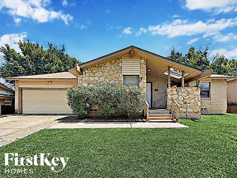 A house with a stone wall and a garage door.