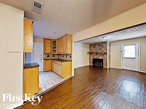 A spacious living room with wood floors and a fireplace.
