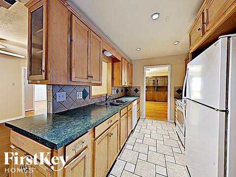 A kitchen with wooden cabinets and a white refrigerator.