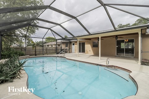 A swimming pool under a glass roof in a residential area.