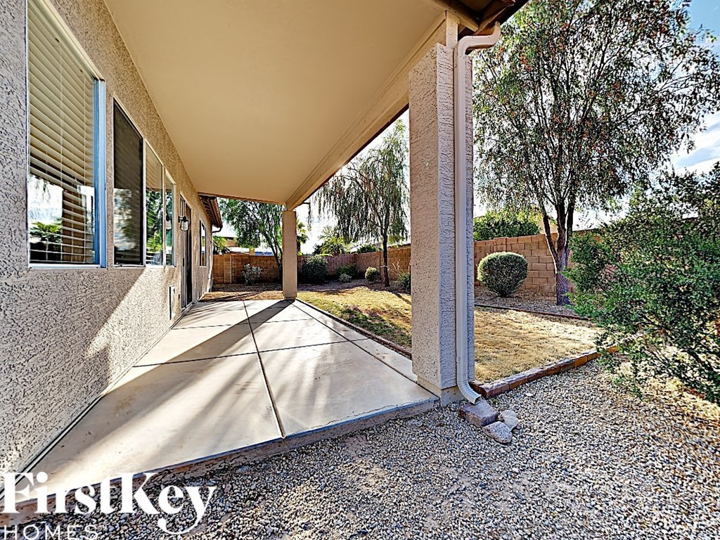 a covered patio with a yard and trees