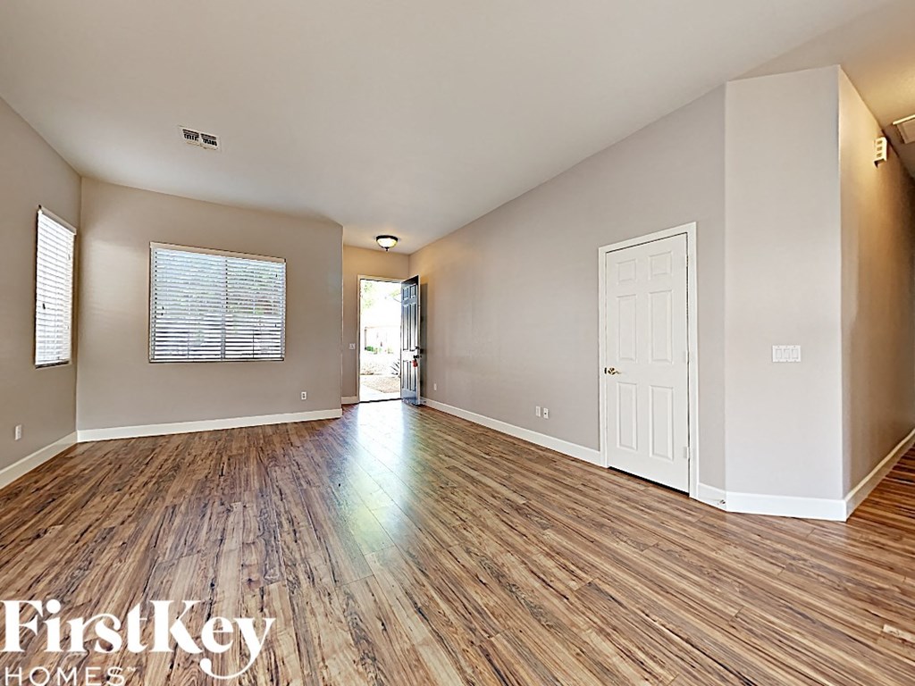 the living room and dining room with wood flooring and a white door