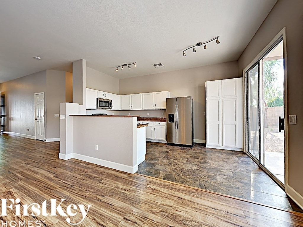 an open kitchen and living room with a sliding glass door