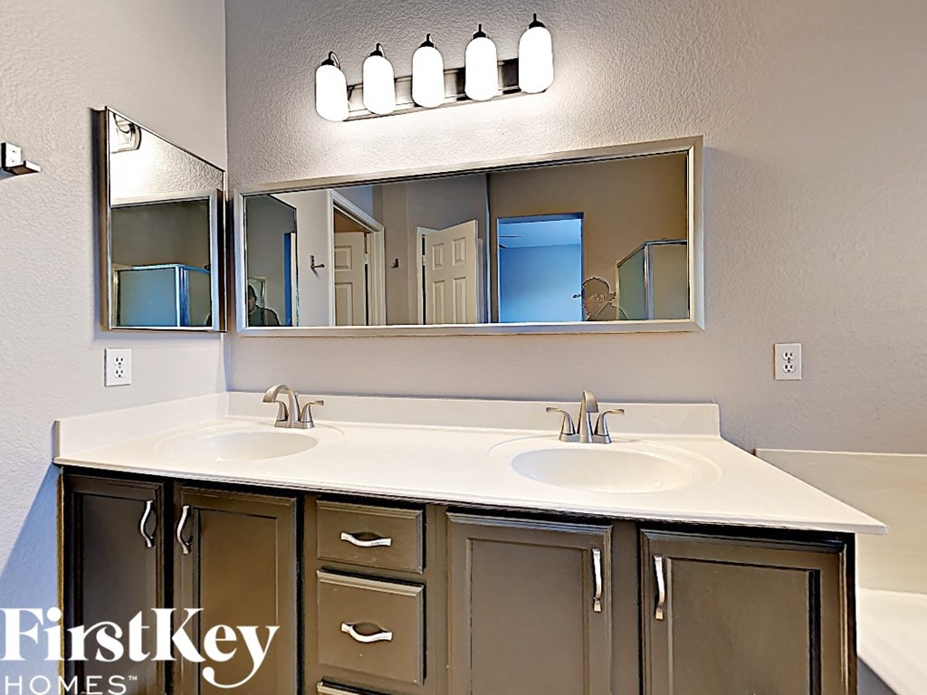 a bathroom with two sinks and a large mirror