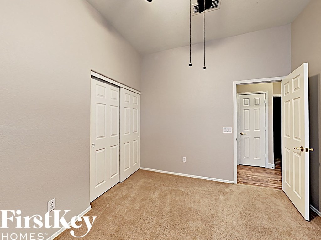 a bedroom with two closet doors and a door to a hallway