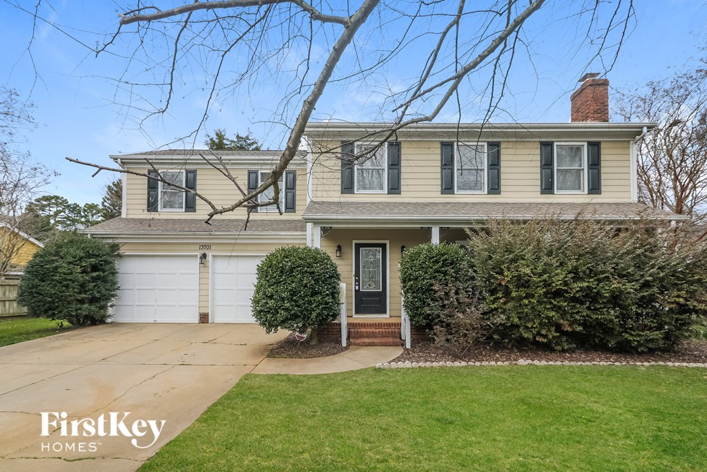 a home with a white garage door and a lawn