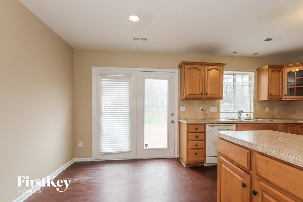 an empty kitchen with wooden cabinets and a door to a patio