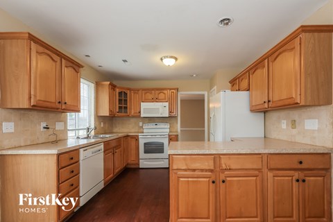 a kitchen with wooden cabinets and white appliances and a counter top