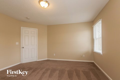 a bedroom with a carpeted floor and a white door