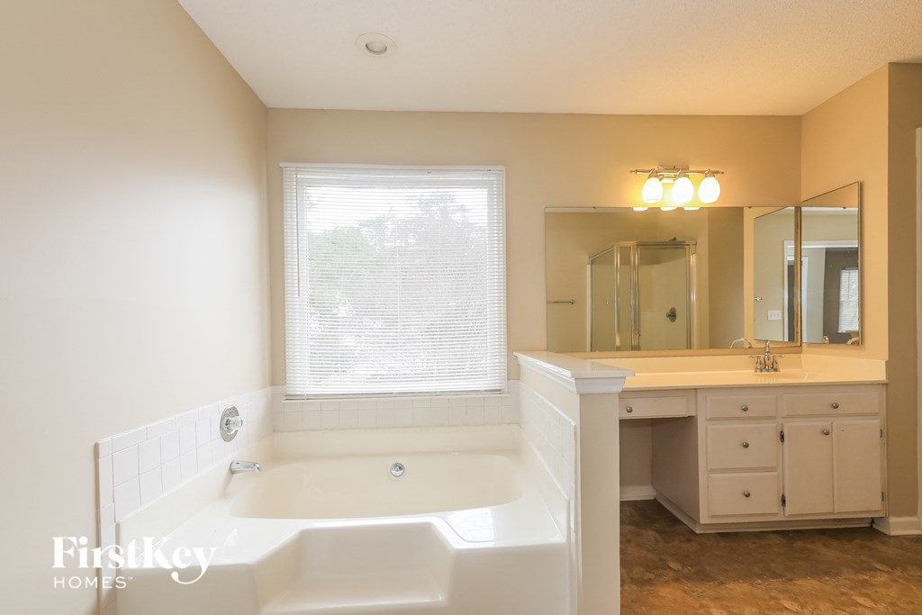 a bathroom with a tub and a sink and a mirror