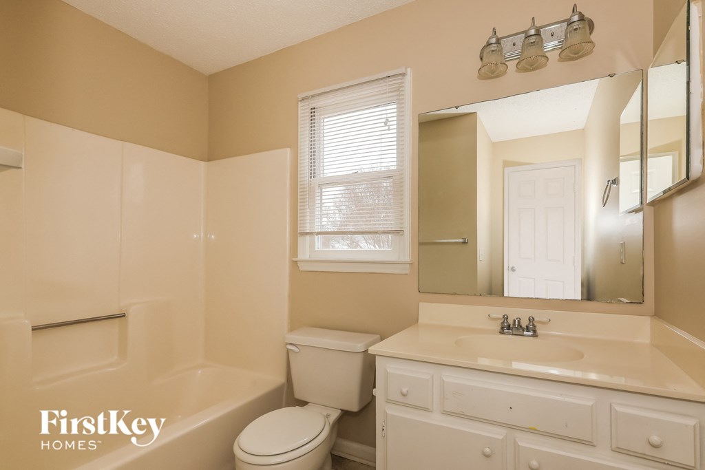 a bathroom with a toilet and a sink and a mirror