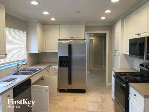 a kitchen with a stainless steel refrigerator and a sink