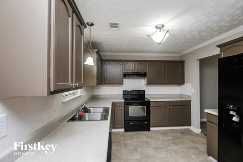 A kitchen with a black stove top oven and a white counter top.