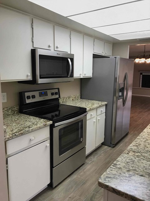 A kitchen with a stove top oven, microwave, and refrigerator.