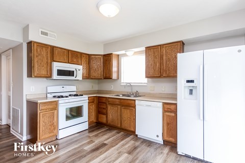 A kitchen with wooden cabinets and white appliances.