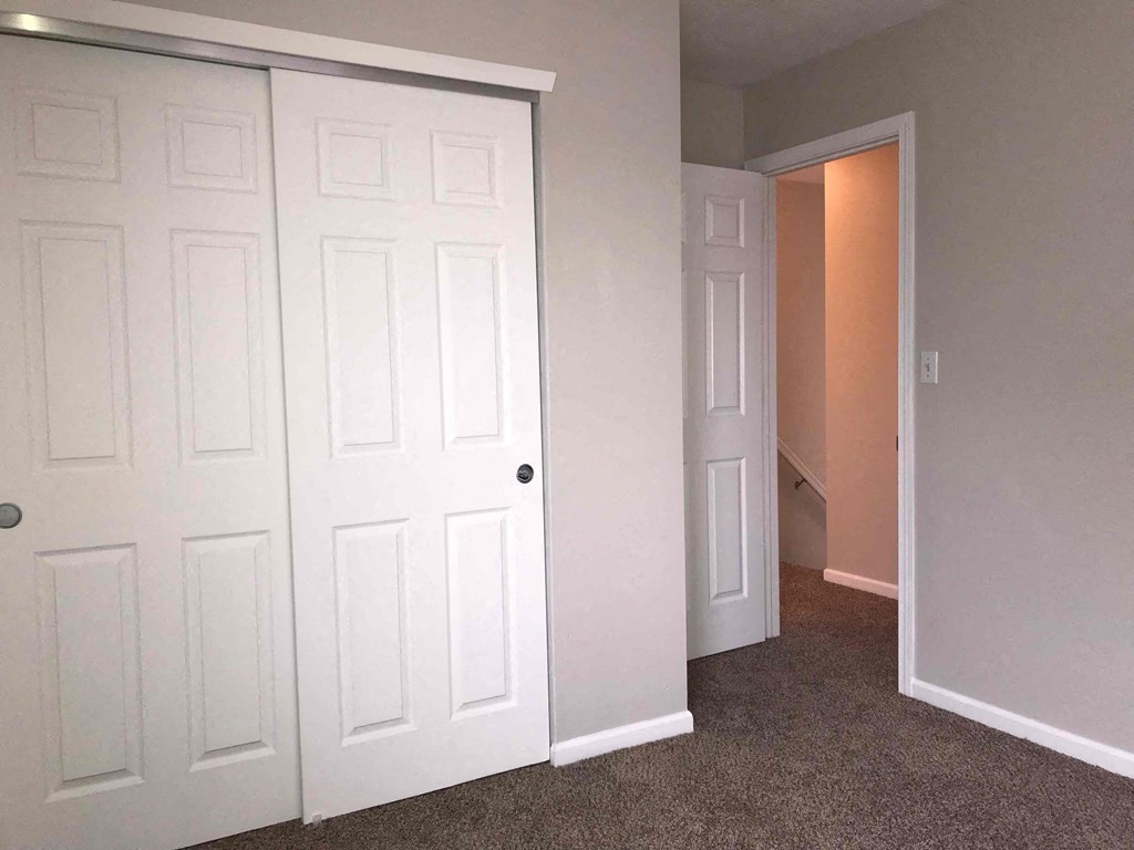 a bedroom with two closets and a door to a hallway