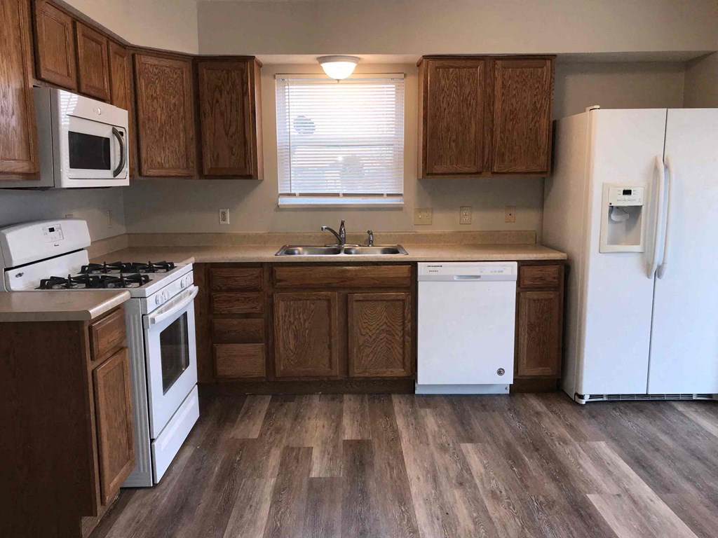 a kitchen with white appliances and wooden cabinets