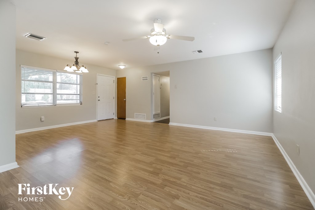 the living room and dining room with hardwood flooring and a ceiling fan