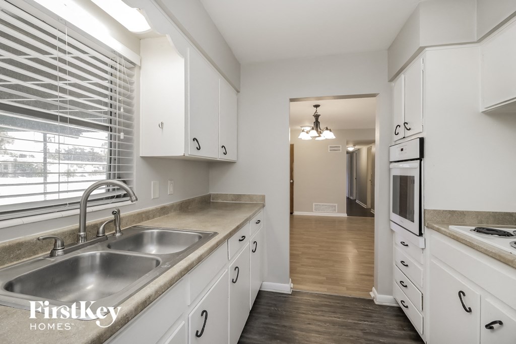 a kitchen with white cabinets and stainless steel appliances and a window