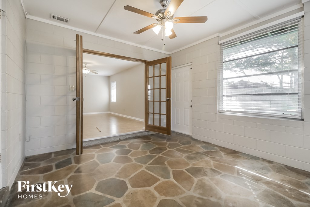 an empty room with a window and a ceiling fan