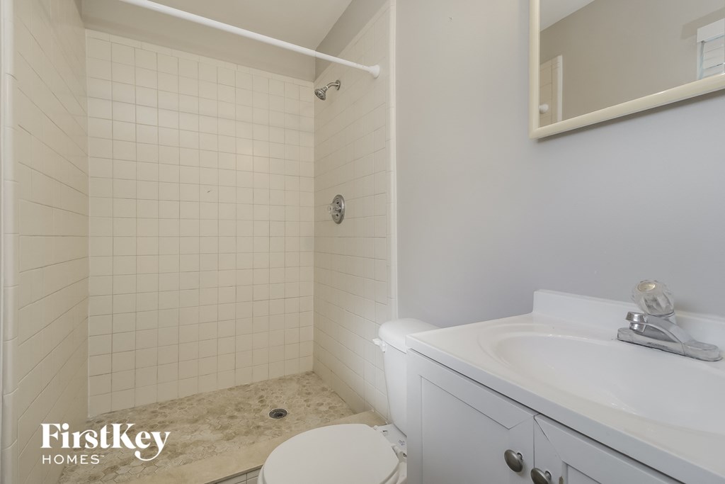 a white bathroom with a sink toilet and shower
