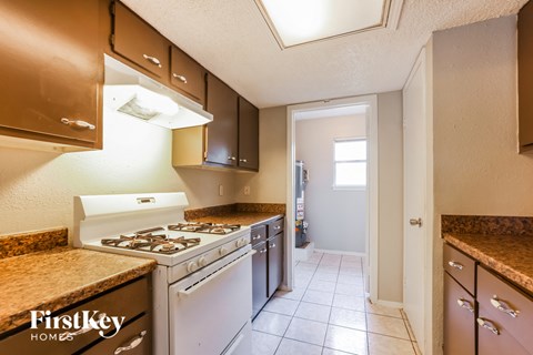A kitchen with a stove top oven and a range hood.