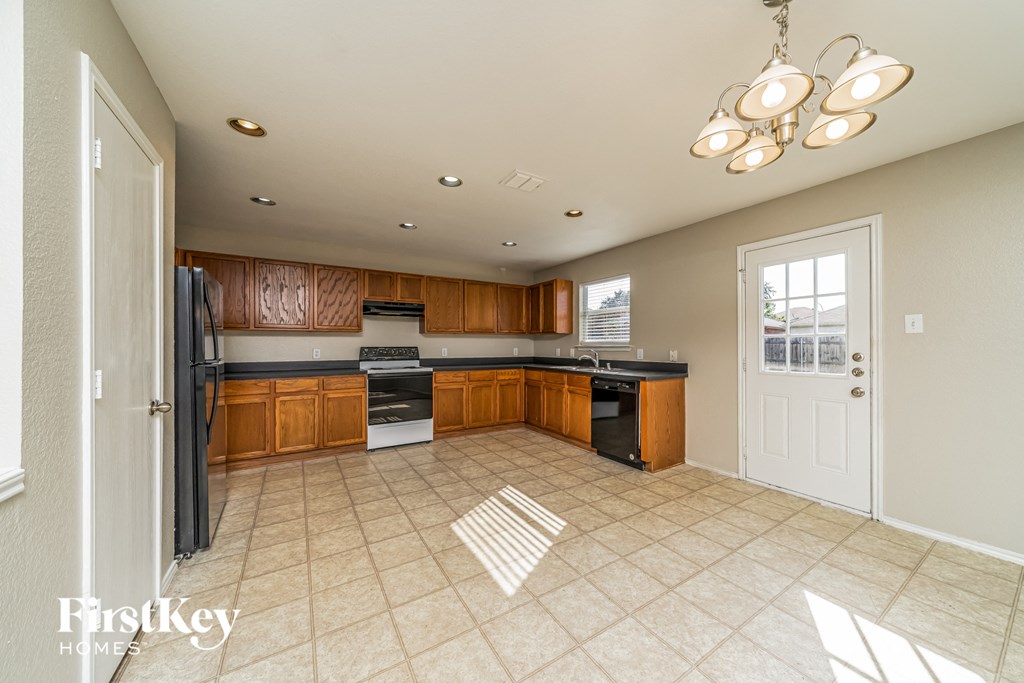 a large kitchen with black appliances and wooden cabinets
