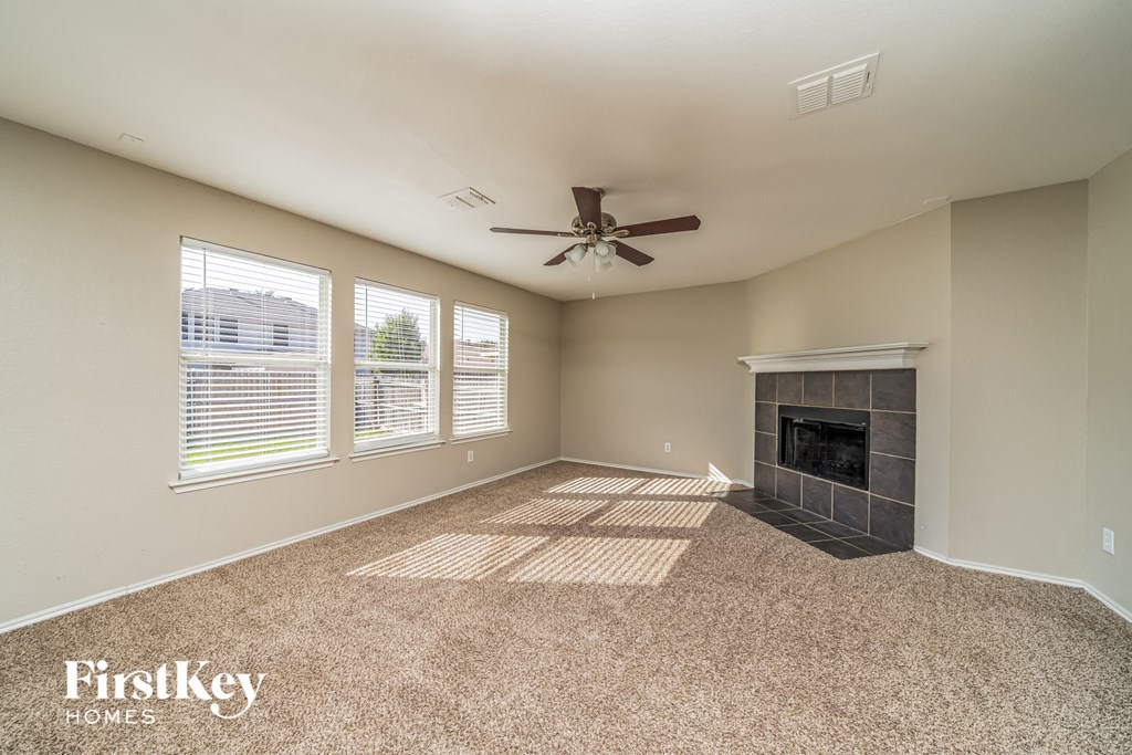a living room with a fireplace and a ceiling fan