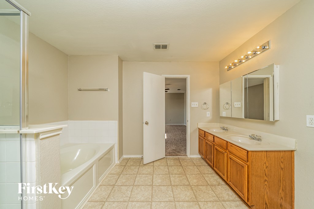 a bathroom with a tub and a sink and a mirror